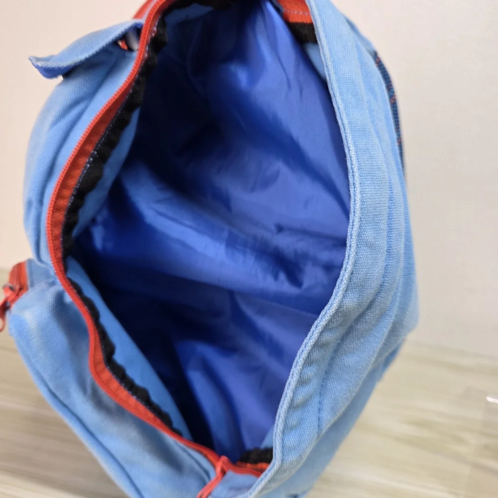 KAVU Denim Blue Sling Backpack with Orange Accents, Adjustable Rope Strap